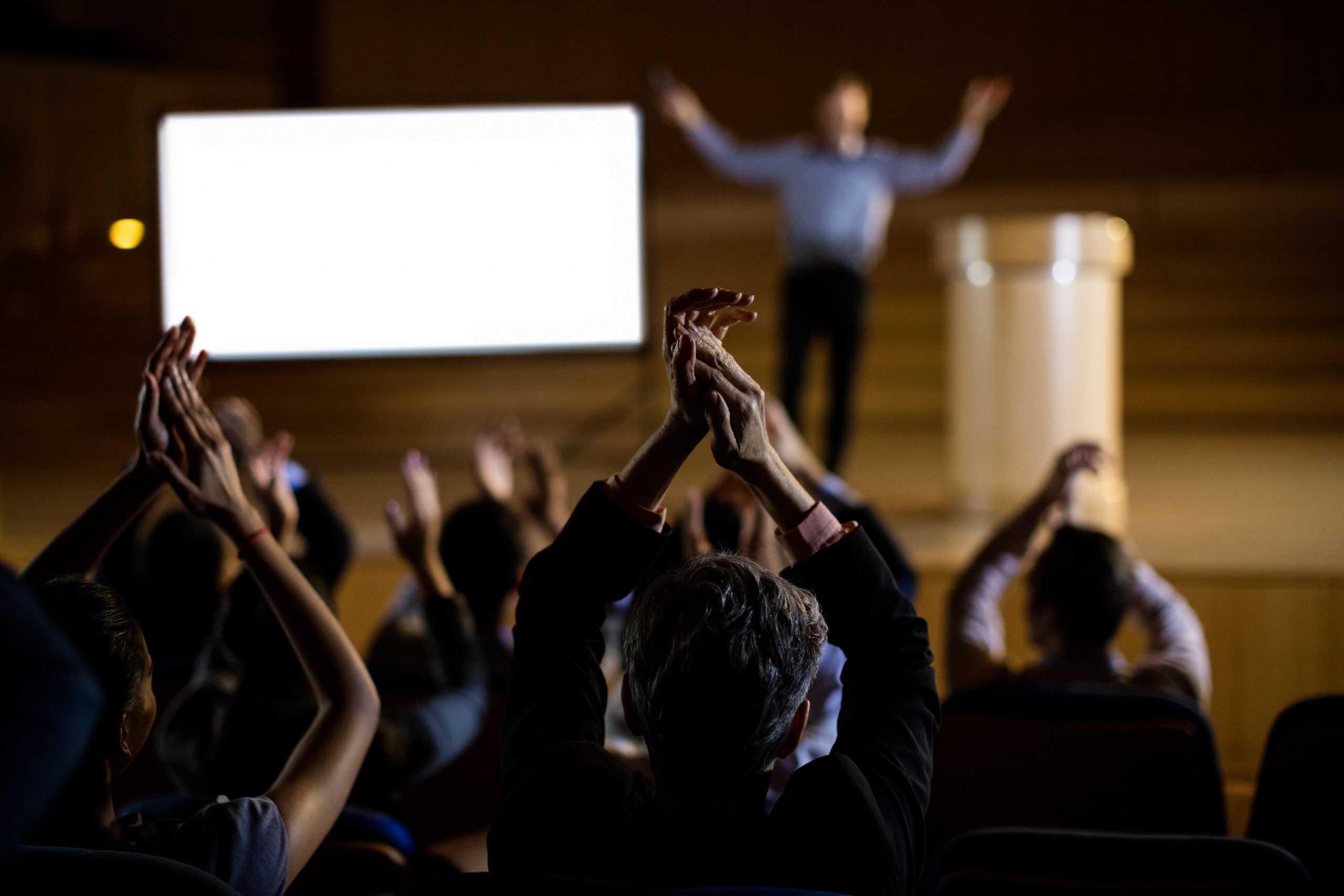 Audience applauding speaker after conference presentation at conference center